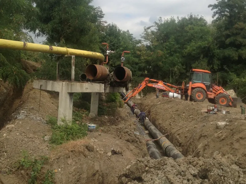 Tranșee cu conducte de termoficare preizolate și excavator, la devierea unei rețele termice